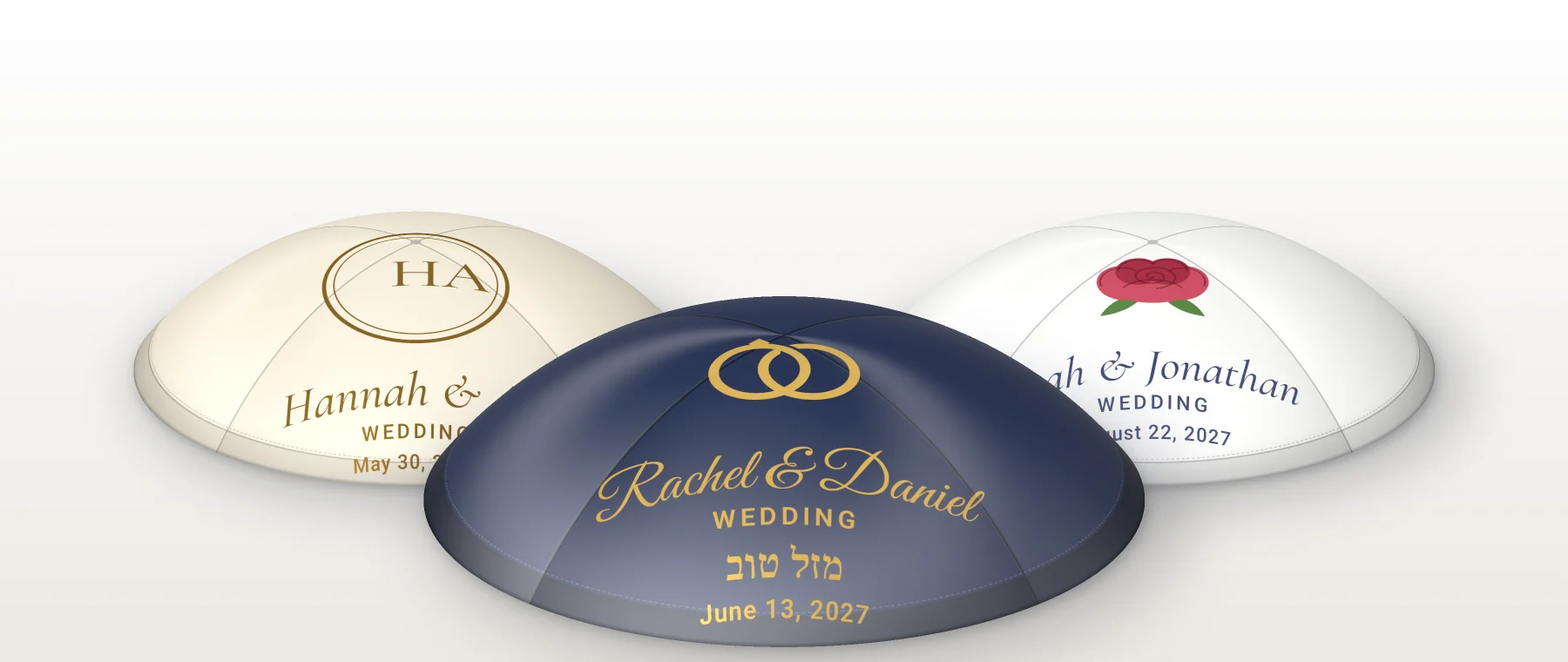 Three satin kippahs: navy with gold rings and the names Rachel and Daniel in front, ivory with a gold monogram and white with a red rose behind. Rendered picture.