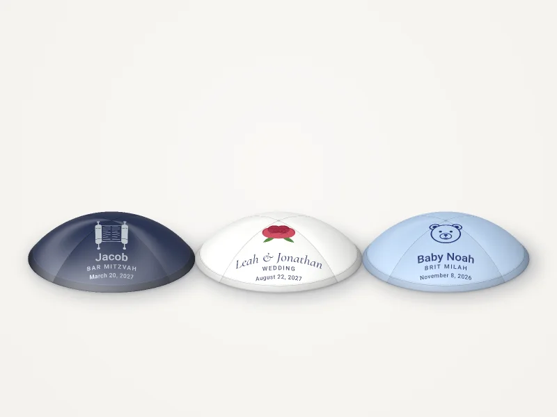 Three rendered kippahs: navy with a Torah scroll, white with a red rose, sky blue with a little bear