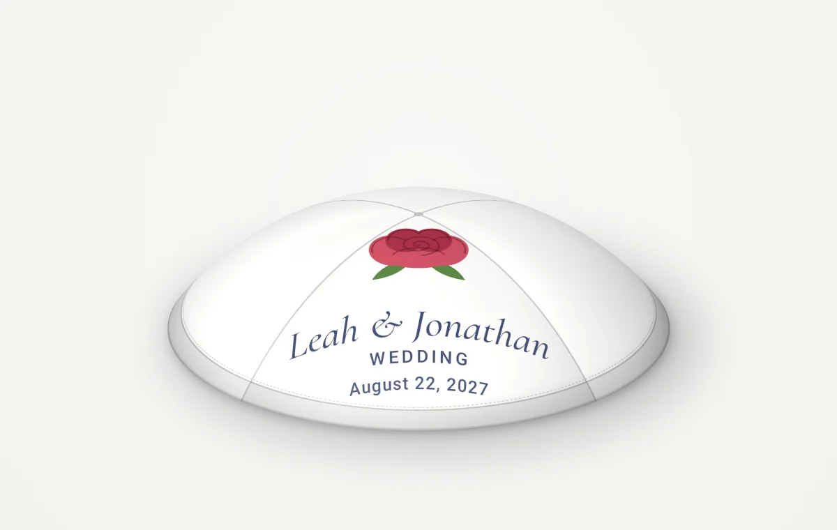 A single white satin kippah with a red rose and the names Leah and Jonathan, rendered picture